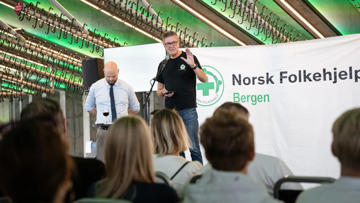 Jorge Dahl ønsker velkommen til den spesielle innsamlingsaksjonen, og gir publikum en kort into til Norsk Folkehjelps mineryddingsarbeid.