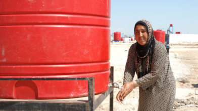 Syrisk kvinne vasker hendene under koronapandemien.