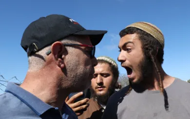 En israelsk bosetter skriker opp i ansiktet på en palestiner