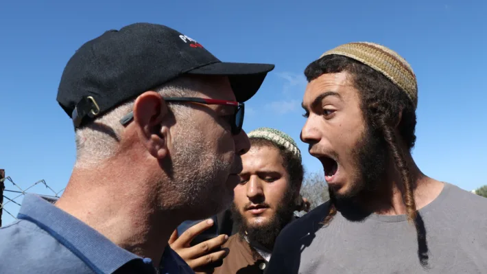 En israelsk bosetter skriker opp i ansiktet på en palestiner