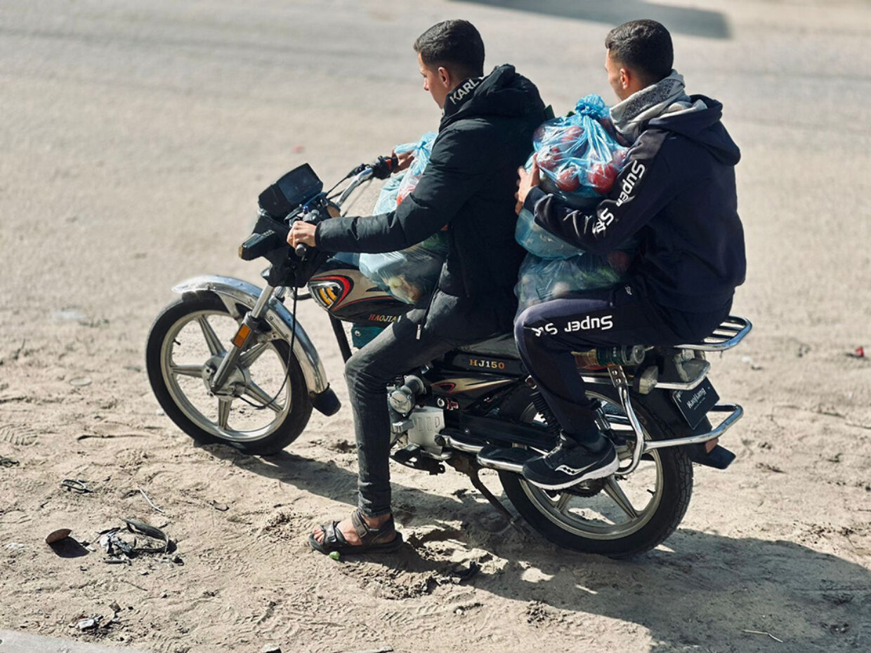 Matutdeling i Gaza. To menn på moped distribuerer mat i Gaza