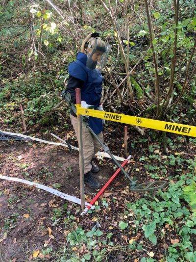 Snezana Djukovic demonstrating use of her metal detector NOTE picture taken on already cleared land