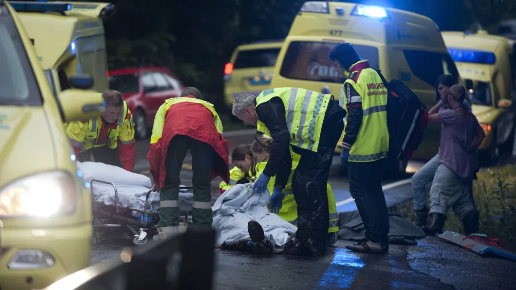 Ronny Frantzen (i rød jakke med ryggen til) og makkeren får sin pasient, som de skal frakte til sykehus.