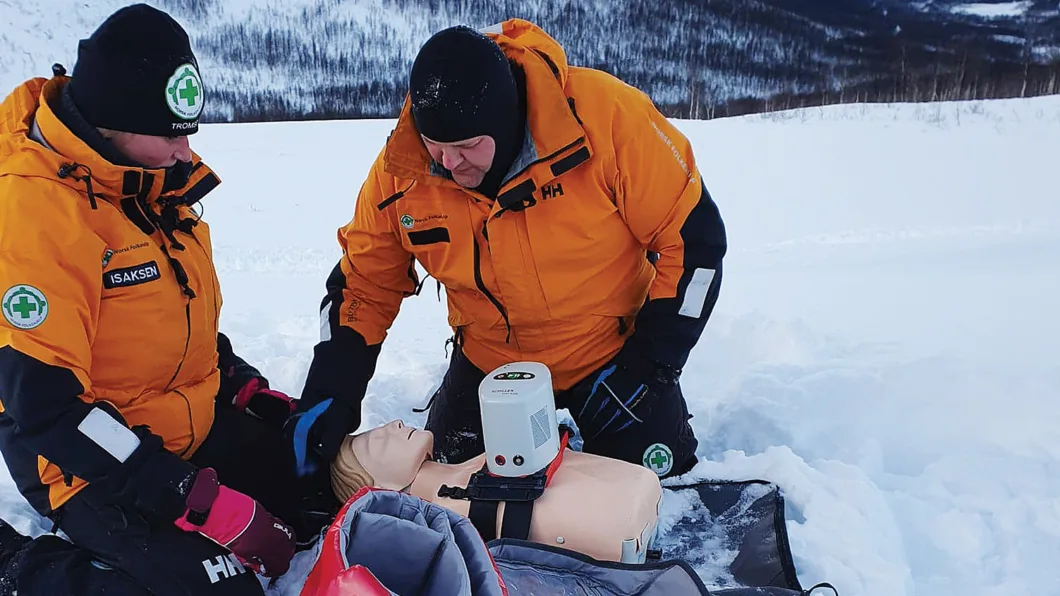 Mannskaper i Norsk Folkehjelp Tromsø tester mekanisk kompresjon under skikkelige vinterforhold. Denne type verktøy har ikke vært brukt blant frivillige tidligere, og fikk også oppmerksomhet i lokal presse.