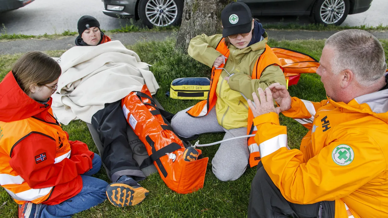 Oddgeir instruerer Signe Helland Ommundsen (t.v.) og Ronja Løknes Oldeide i bruken av en vakuumspjelk som skal stabilisere beinbruddet til markør Jonas Sjølyst.