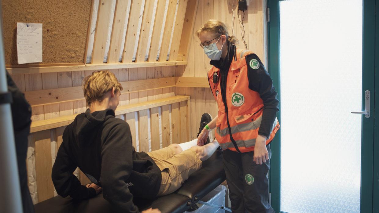 Camilla Sætre behandler Morgan Hellebergshaugen som ble skadet under en av de mange fotballkampene som spilles på Utøya i løpet av sommeren.