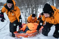 Freddy Kviteberg fra Norsk Folkehjelp Lenangen og Nina Pettersen fra Norsk Folkehjelp Stjørdal samarbeider om å dra båra med pasienten opp skrenten.