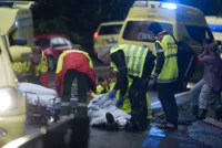 Ronny Frantzen (i rød jakke med ryggen til) og makkeren får sin pasient, som de skal frakte til sykehus.