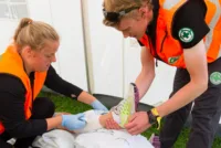 Mannskaper fra Norsk Folkehjelp behandler en skade under Norway Cup i 2016.