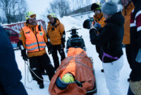 Steve Skare i Norsk Folkehjelp Tromsø viser hvordan man frakter en pasient trygt på båre under vinterforhold.