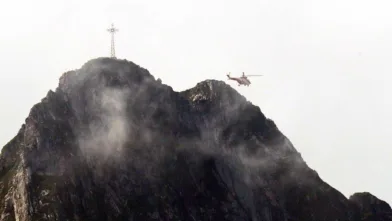 Et redningshelikopter flyr over Giewont-fjellet i Polen i august 2019. Denne dagen ble 150 personer skadd etter at lynet traff korset og spredte seg videre i kjettingene som turgåere bruker til å komme seg opp på toppen.