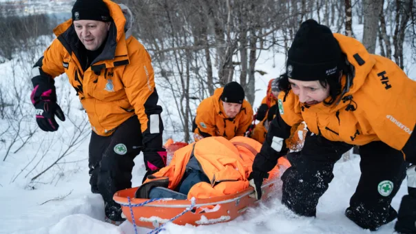Freddy Kviteberg fra Norsk Folkehjelp Lenangen og Nina Pettersen fra Norsk Folkehjelp Stjørdal samarbeider om å dra båra med pasienten opp skrenten.