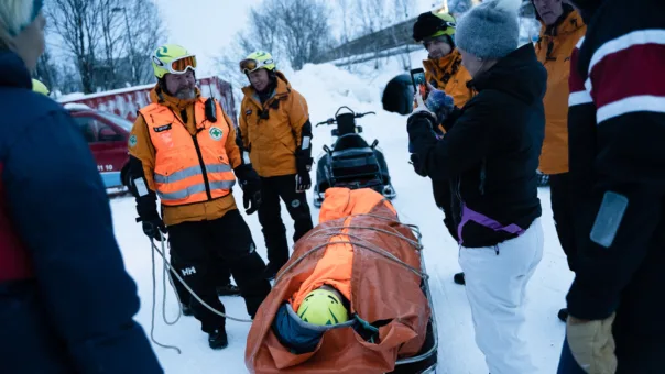 Steve Skare i Norsk Folkehjelp Tromsø viser hvordan man frakter en pasient trygt på båre under vinterforhold.