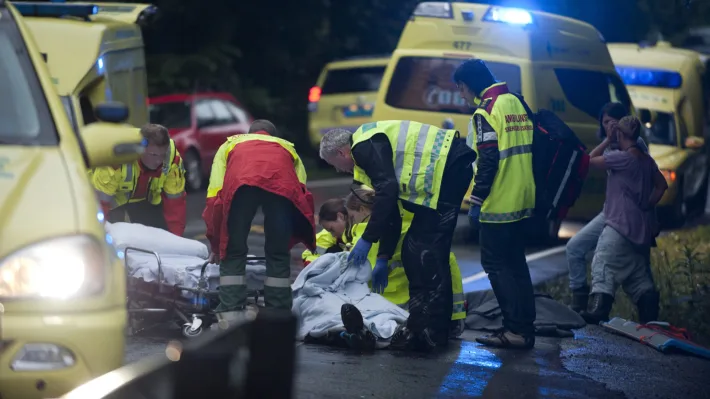 Ronny Frantzen (i rød jakke med ryggen til) og makkeren får sin pasient, som de skal frakte til sykehus.