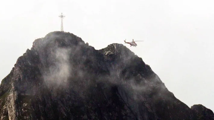 Et redningshelikopter flyr over Giewont-fjellet i Polen i august 2019. Denne dagen ble 150 personer skadd etter at lynet traff korset og spredte seg videre i kjettingene som turgåere bruker til å komme seg opp på toppen.