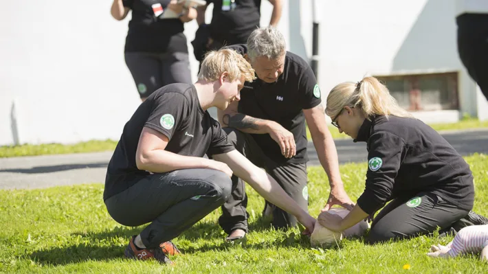 Robin Skjellum (til venstre) viser resten av førstehjelpsinstruktørene hvordan de gjør førstehjelp på barn.