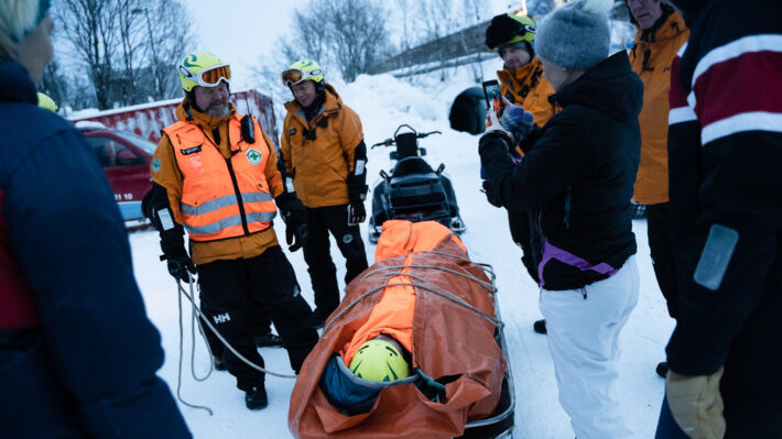 Steve Skare i Norsk Folkehjelp Tromsø viser hvordan man frakter en pasient trygt på båre under vinterforhold.