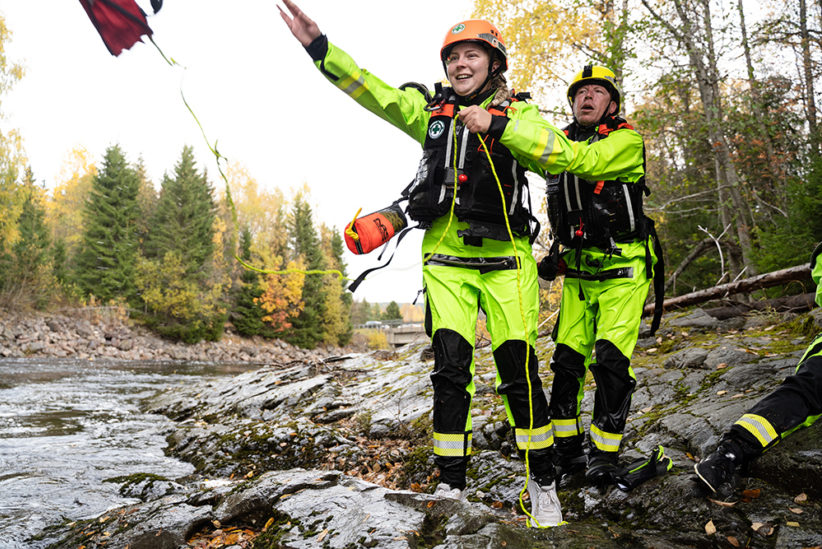 To vannreddere står på land og trener på kasteline