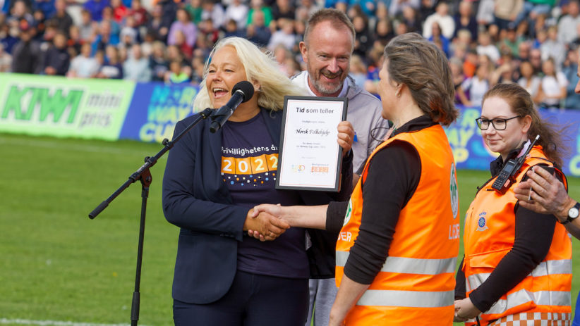 Bildet viser frivillige fra Norsk Folkehelp som mottar en pris