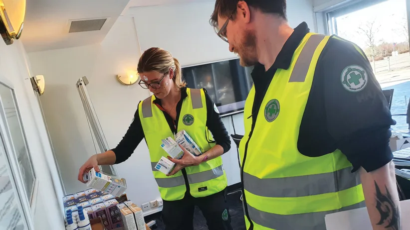 Bilder viser Eileen Suzann Tennebø Bové og Filip Landrø som finner fram flere hygieneartikler til flyktningene.