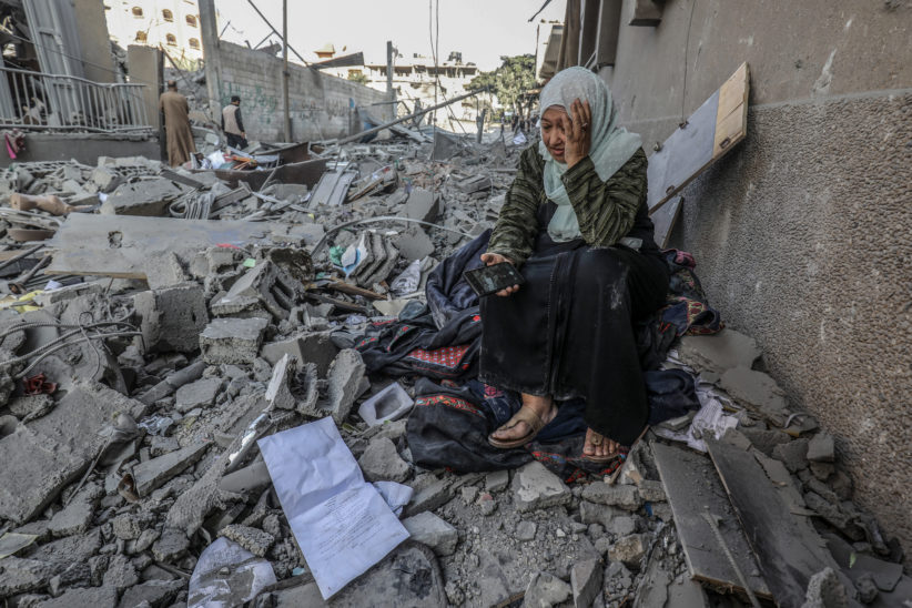 Kvinne i ruinene etter israelske bombeangrep på Gazastripen