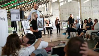 Solidaritetsauksjon er god stemning! Auksjonarius Christer Holm og frivillig i Norsk Folkehjelp, Linda Træet, presenterer ett av de 130 verkene som ble donert av engasjerte kunstnere.
