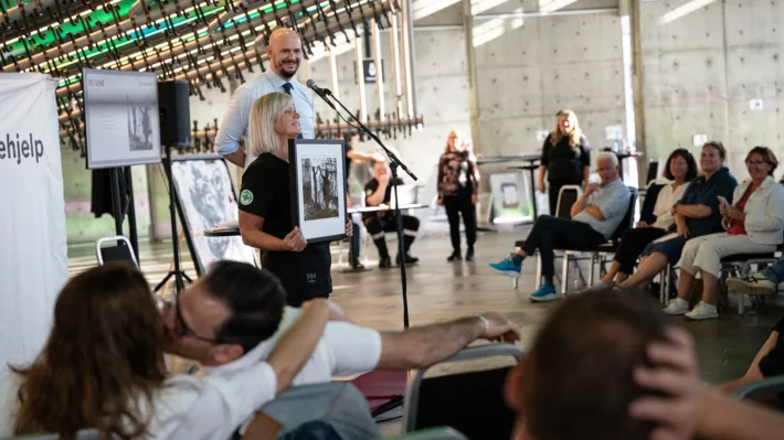 Solidaritetsauksjon er god stemning! Auksjonarius Christer Holm og frivillig i Norsk Folkehjelp, Linda Træet, presenterer ett av de 130 verkene som ble donert av engasjerte kunstnere.